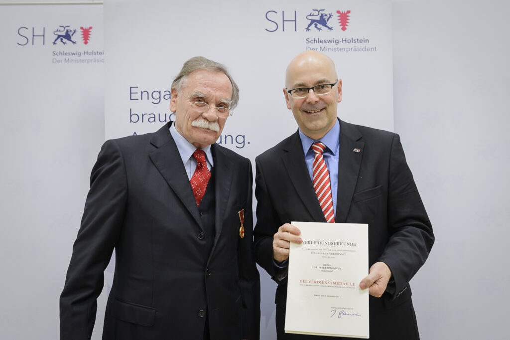 Torsten Albig überreicht die Verdienstmedaille des Verdienstordens der Bundesrepublik Deutschland an Dr. Peter Bergmann. Foto: Frank Peter